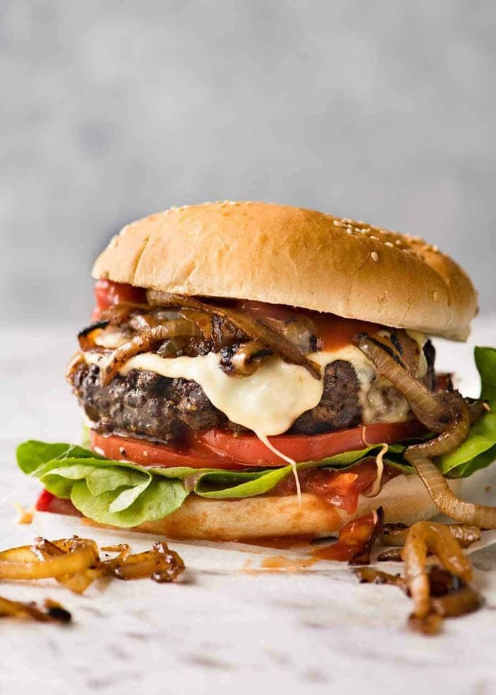 large juicy burger how long to cook burgers with grilled onions melted cheese ketchup tomatoes lettuce 