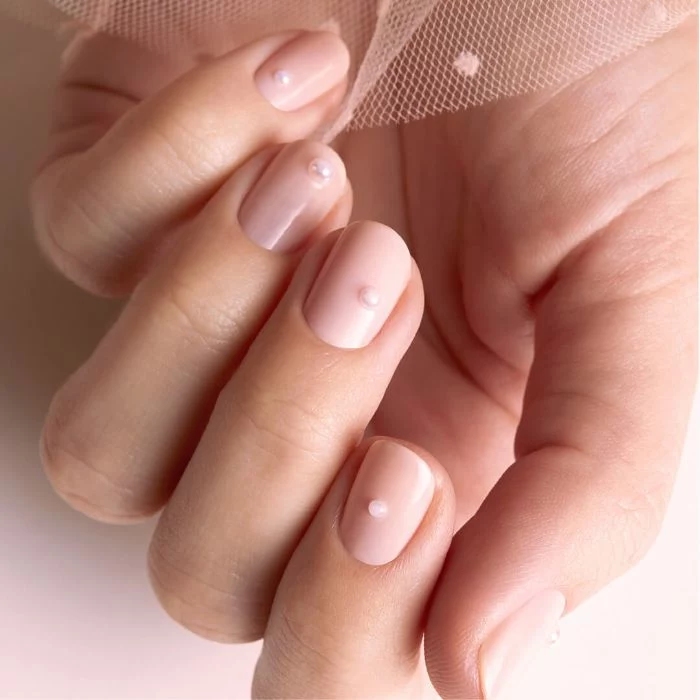 nude nail polish decorated with small white pearl on each finger summer nails 2021