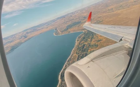 photo taken through the window of plane travel tips wing of the plane visible