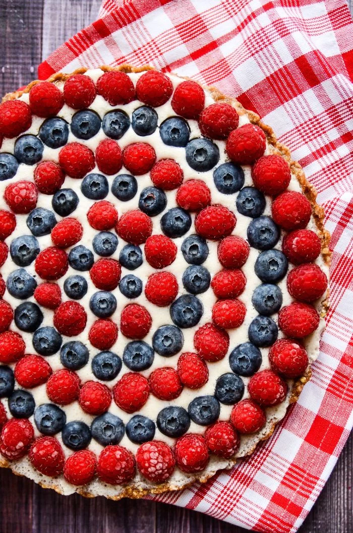raspberry blueberry tart decorated in circles 4th of july recipes red and white cloth under it