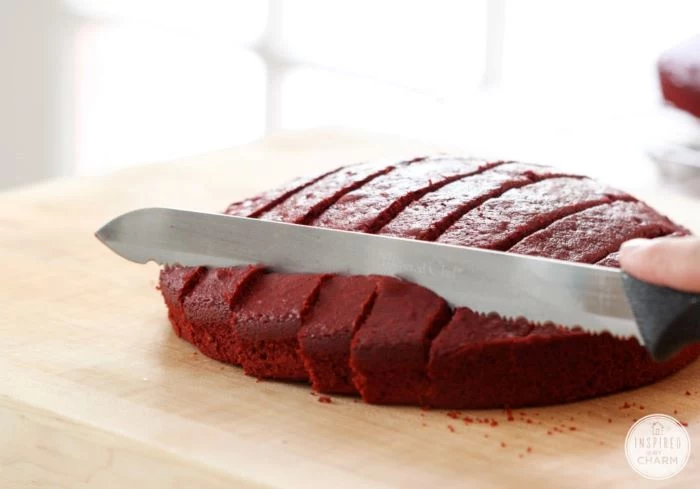 red velvet cake being cut into small bites with knife traditional 4th of july foods on wooden cutting board