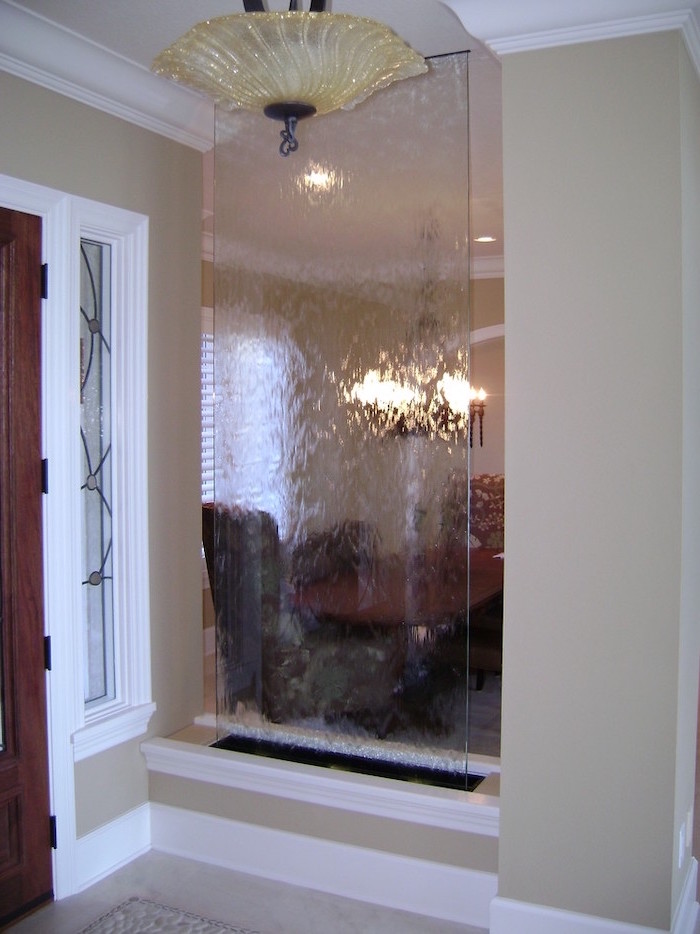 room divider made of glass separating dining room hallway tabletop water fountain water falling down