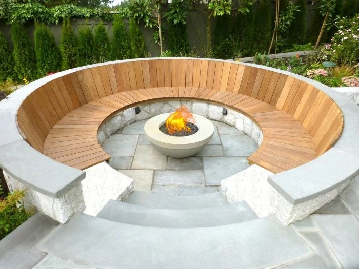 round wooden bench around concrete bowl filled with rocks how to make a fire pit fire burning inside