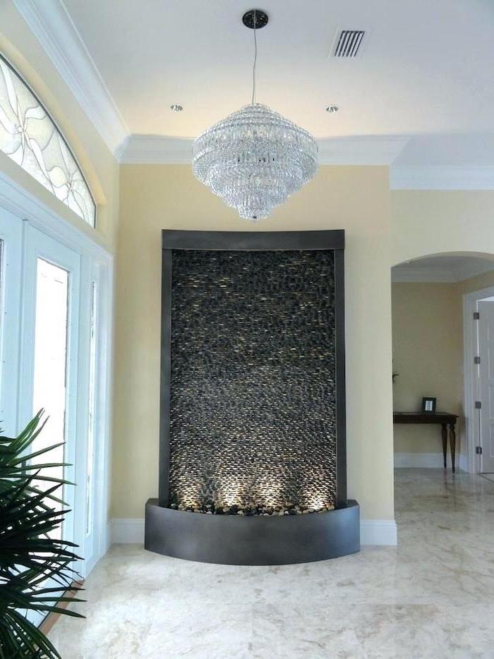 standing water fountain made of mosaic small black stones indoor water features water falling into pot filled with stones lights on the bottom