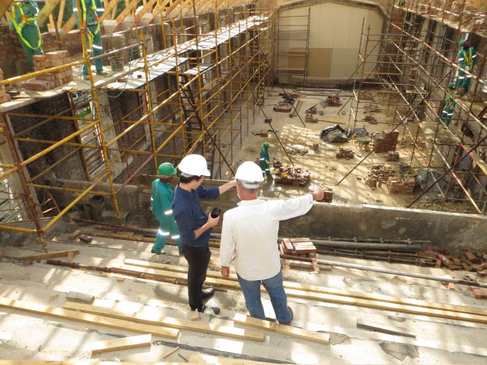 two men wearing safety gear standing at construction site construction business ideas workers around them