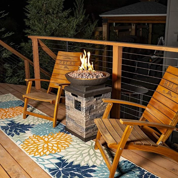 two wooden chairs on rug with orange blue flowers backyard fire pit ideas standing concrete bowl with rocks