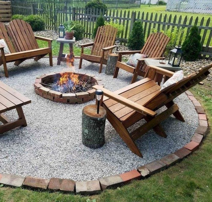 wooden lounge chairs arranged in circle around backyard fire pit ideas placed on gravel