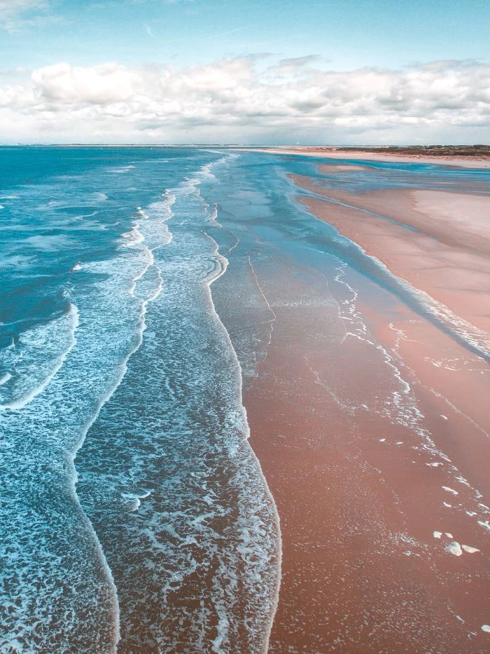 aerial photo of waves crashing into empty beach with sand beach desktop wallpaper