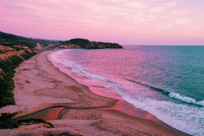 beach aesthetic photographed at sunset waves crashing into the beach