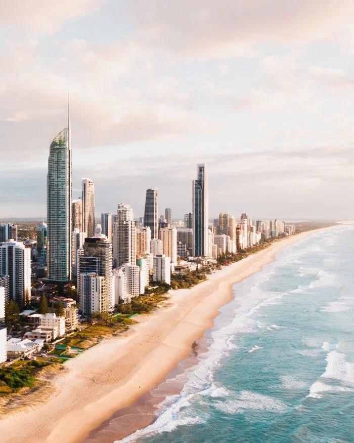 beach background hd tall buildings skyscrapers on beach waves crashing into it aerial view
