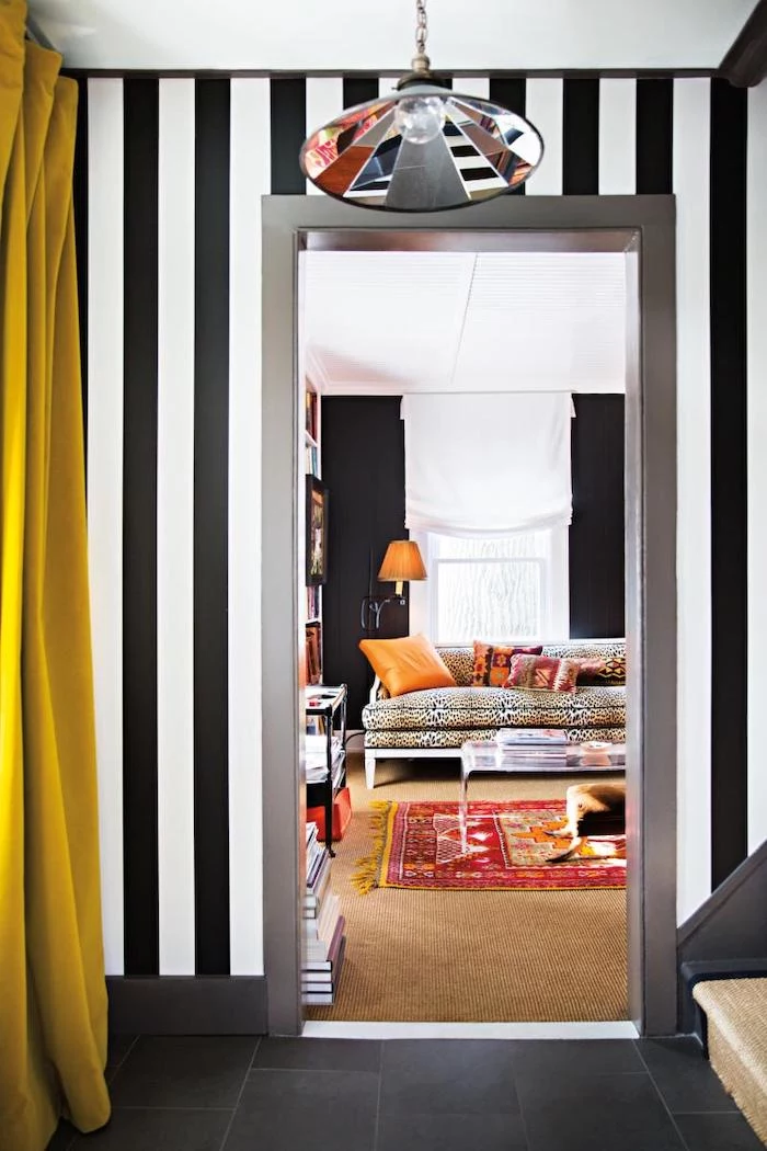 black and white stripes wallpaper on the walls black tiles on the floor narrow hallway ideas colorful light fixture