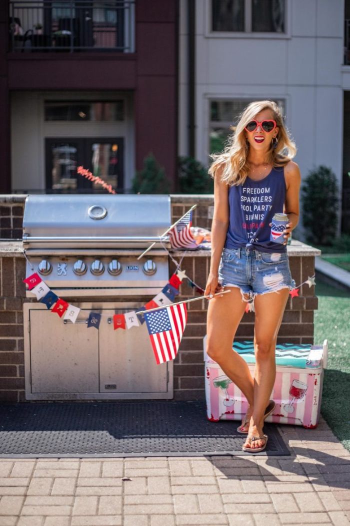 blue top denim shorts worn by blonde woman 4th of july clothes standing next to grill