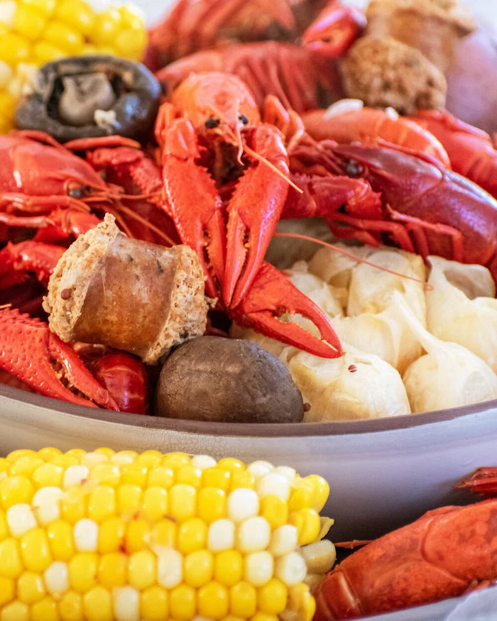 close up photo of crawfish boil how to make a seafood boil with sausages garlic onion potatoes corn on the cob