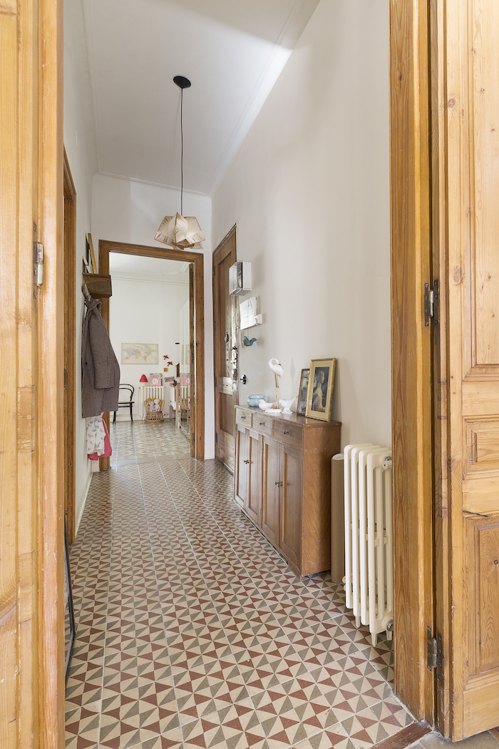 colorful tiles on the floor white walls wooden walls doors and cupboard entryway wall decor framed art on it