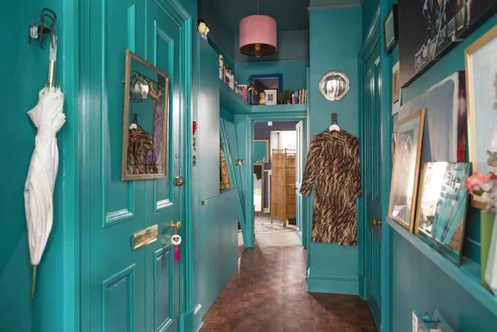 entryway wall decor turquoise walls and doors with open shelving lots of framed art and books on the walls
