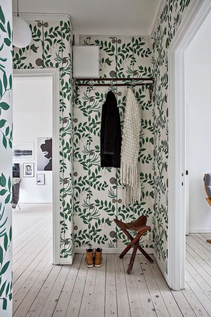 floral wallpaper with green leaves light wooden floor entryway decor black metal hangers