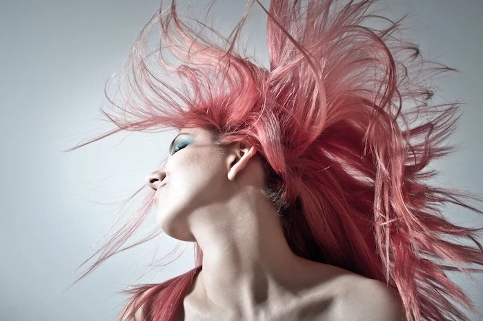 gray background woman with long black hair floating in the air best hair mask green eyeshadow