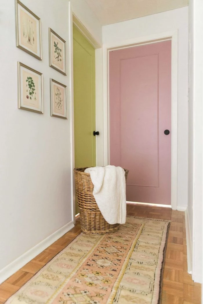 green and pink doors white walls entryway wall decor framed art on the wall colorful rug on the wooden floor