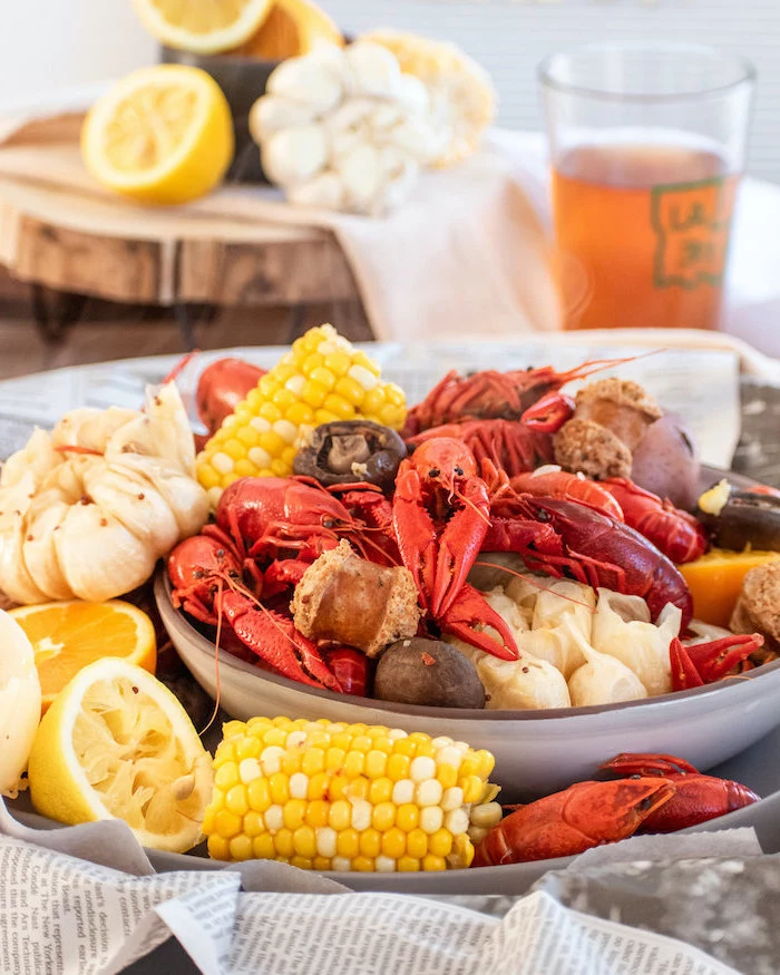 how to make a seafood boil crawfish boil with onion garlic corn on the cob potatoes sausages placed in large bowl