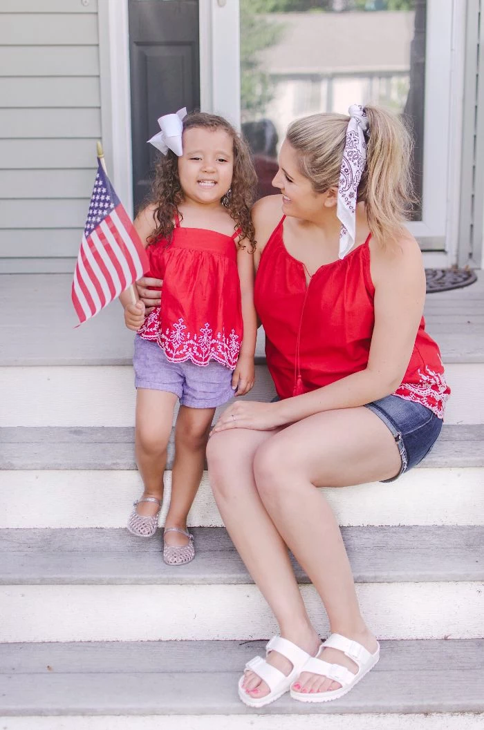 mom and daughter sitting on stairs fourth of july shirts wearing denim shorts red tops