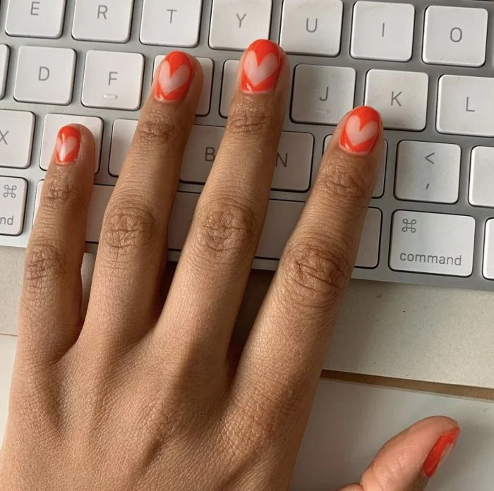 negative space hearts on orange nail polish on short nails gel nail designs