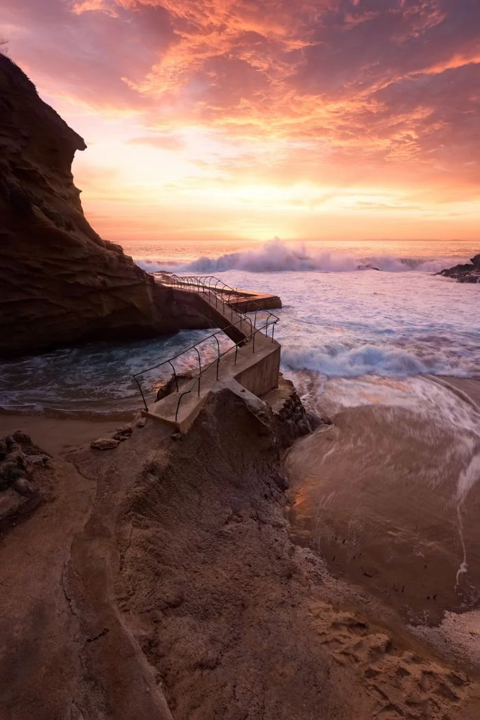 pathway leading around rock summer aesthetic wallpaper waves crashing into the rocks at sunset