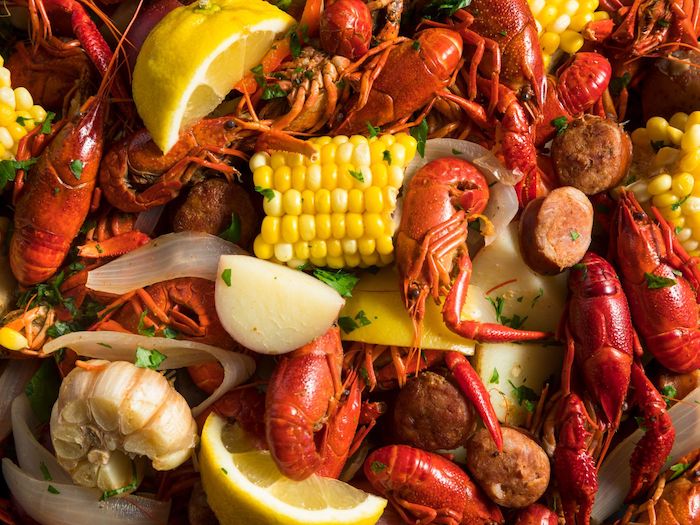 seafood boil sauce crawfish corn on the cob potatoes garlic lemon wedges