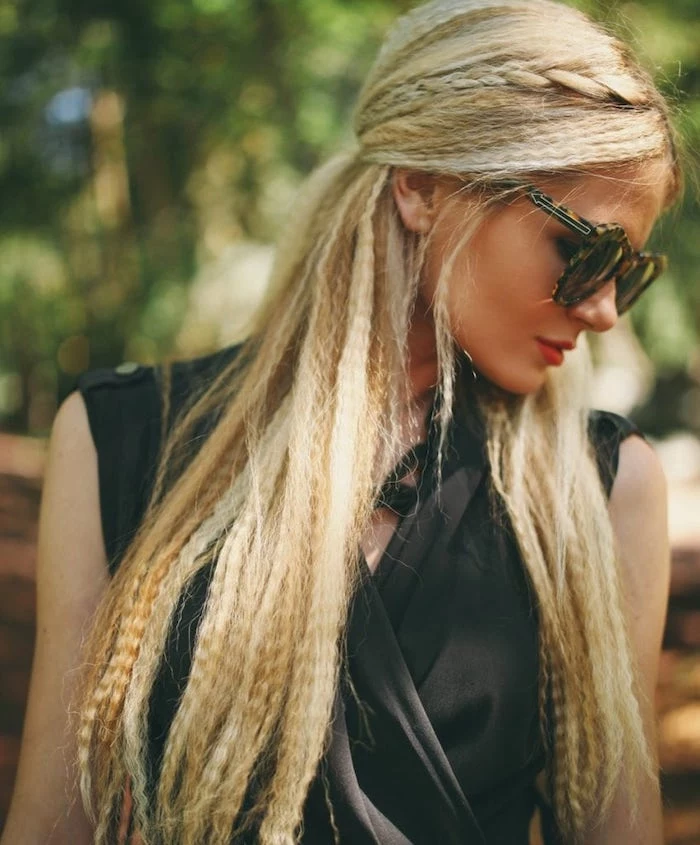 short crimped hair woman with long blonde hair with side braid wearing black top sunglasses