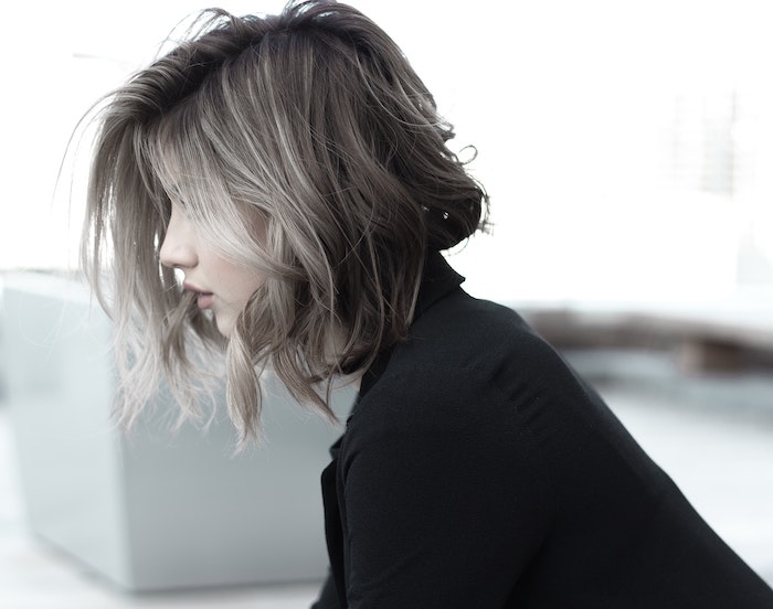 short wavy hair with gray balayage best hair mask for damaged hair woman wearing black shirt