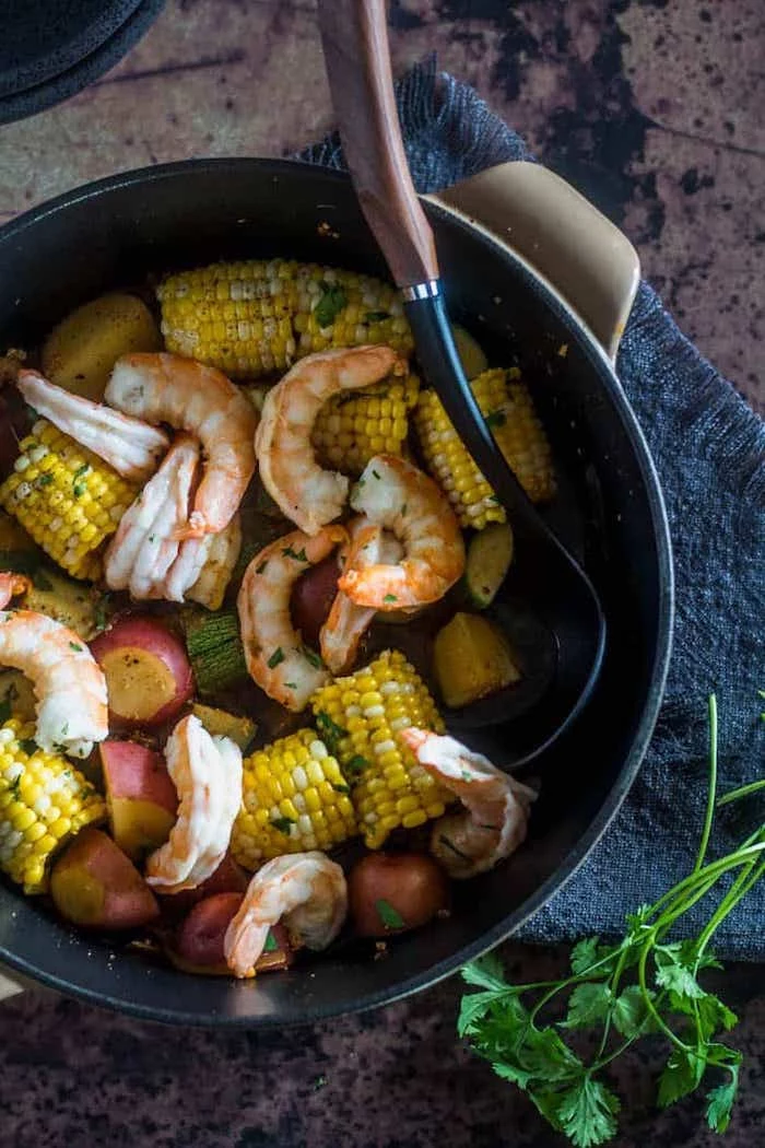 shrimp boil recipe mexican style corn on the cop potatoes inside pot garnished with parsley