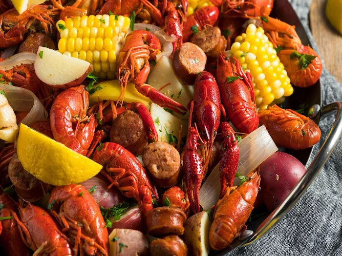 southern crawfish boil with sausages potatoes corn on the cop seafood boil recipe garnished with parsley