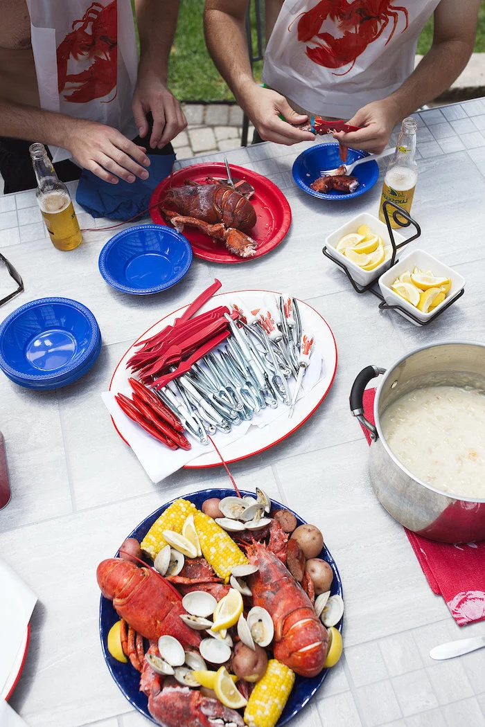 table with different plates and bowls how to boil shrimp lobster boil with potatoes corn on the cob sausages