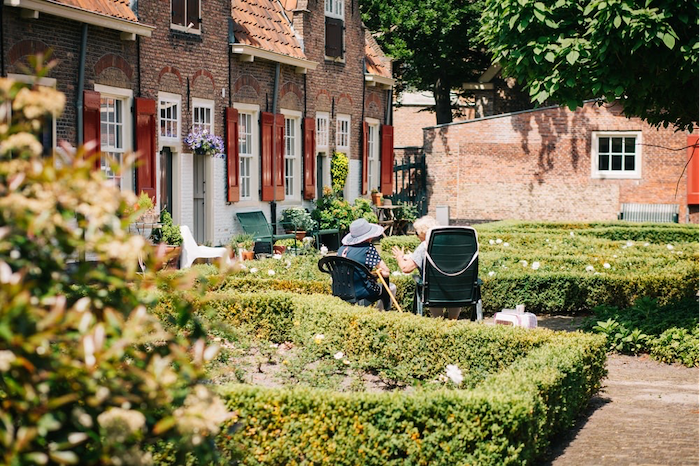 two women sitting on chairs outside talking farmhouse garden table in the backyard