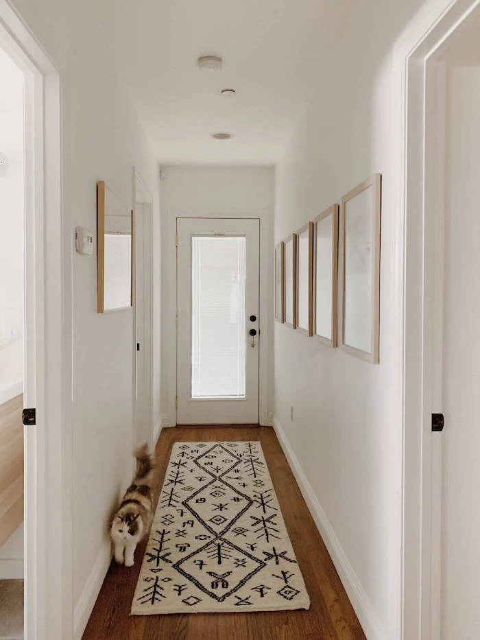 white and black rug on wooden floor entry way decorating ideas framed art hanging on white walls
