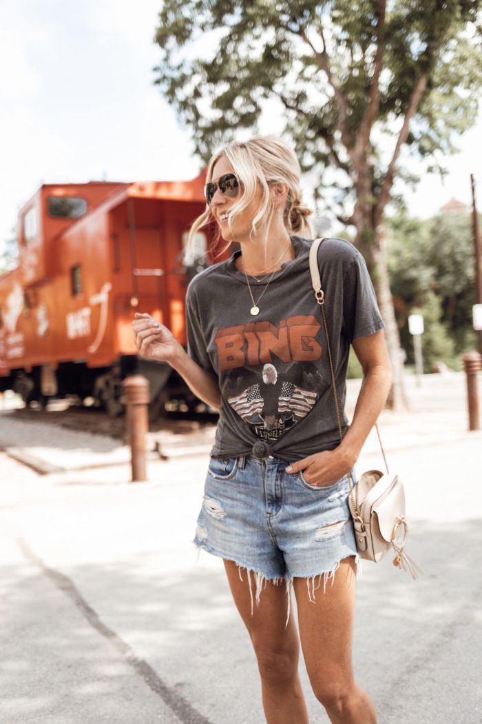 woman wearing denim shorts gray t shirt with american flags on it fourth of july shirts blonde woman