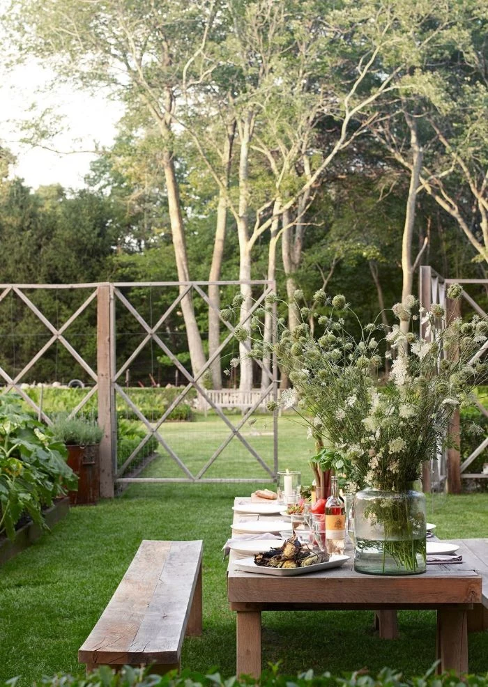 backyard design ideas wooden bench and table in the grass surrounded by plants and trees