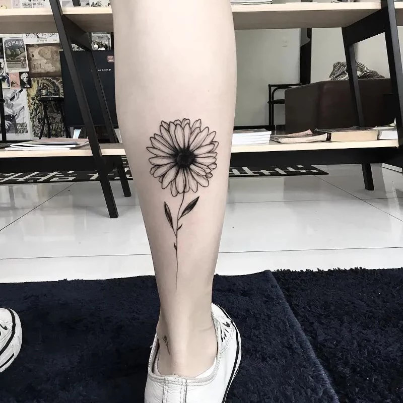 black and white small sunflower tattoo back of leg