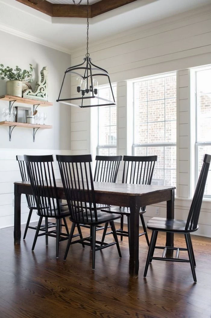 black chairs around vintage table in front of tall windows farmhouse dining room open shelving