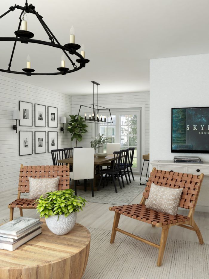 black chandeliers hanging above farmhouse table and chairs in black and white shiplap on the walls