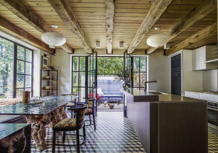 exposed wood beams colorful tiles on the floor modern farmhouse dining room kitcchen island and furniture with colorful textiles