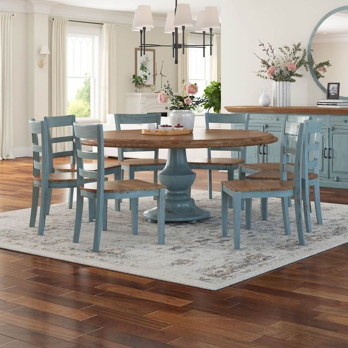 farmhouse dining table round table blue chairs placed on rug vase filled with flowers on top of table