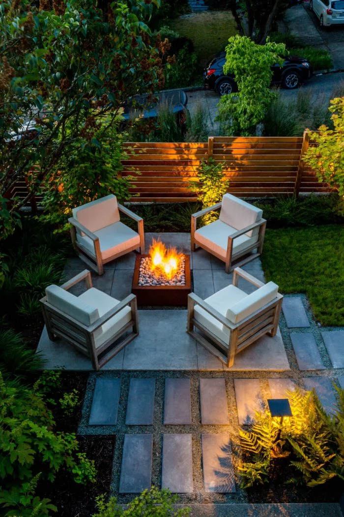 fire pit with four lounge chairs around it with white cushions landscape design ideas tiled pathway