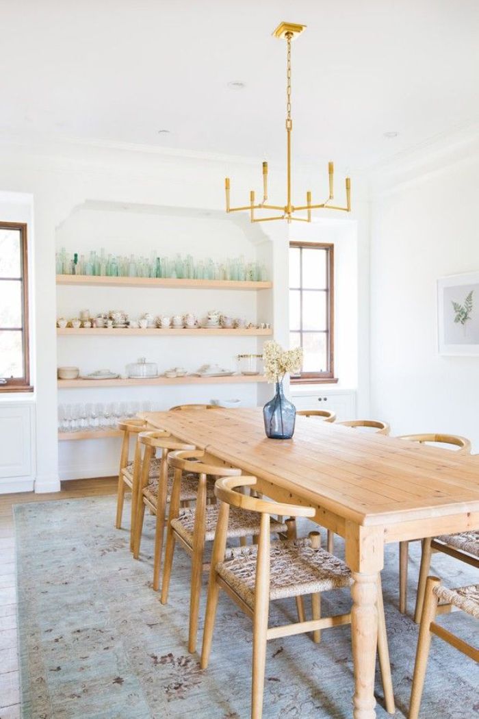 glasses and cups arranged on open shelves on the wall rustic dining table with wooden chairs