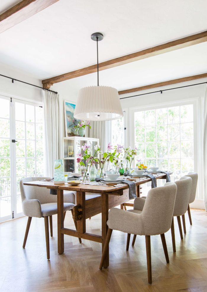 gray chairs around long wooden table farmhouse dining table exposed wood beams on the ceiling