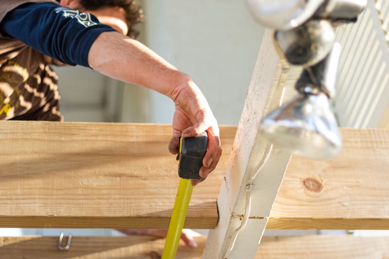 man measuring wood beam remodeling expenses