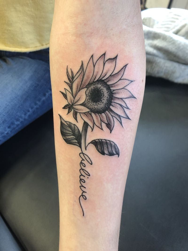 sunflower tattoo in black and white believe written