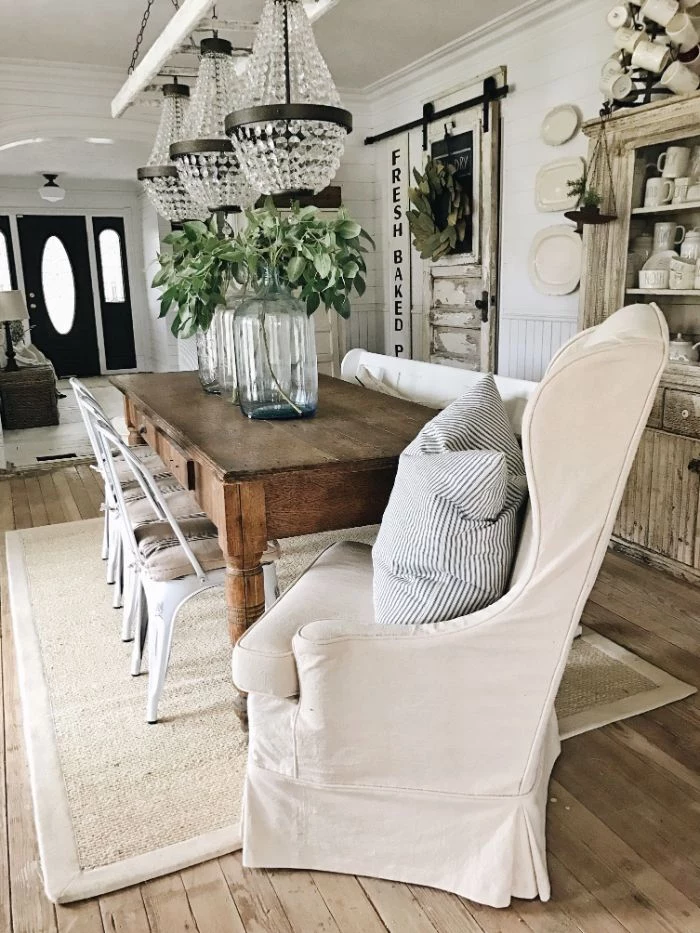 white armchair vintage chairs and table three chandeliers above it barn doors farmhouse kitchen table