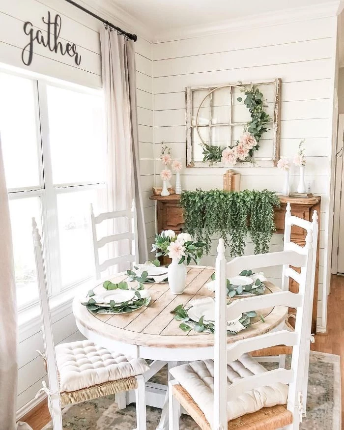 white cushions on chairs small round table farmhouse dining table greenery decorations