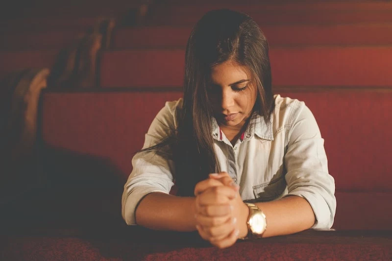 girl who is praying in the church quite time