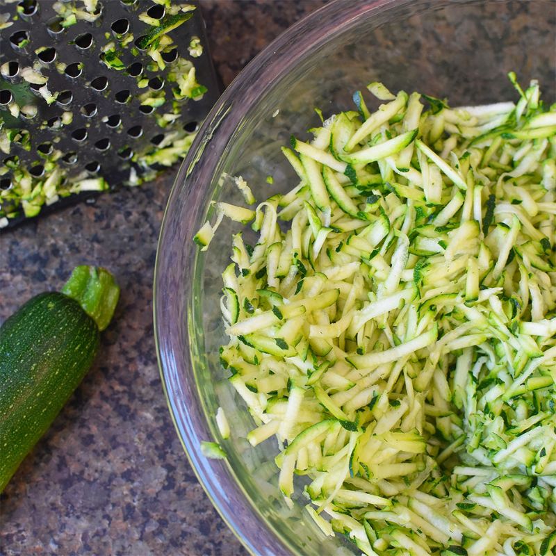 grated zucchini fritters recipe in glass bowls